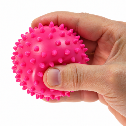 Medium pink 7.5 cm spiky massage ball in hand