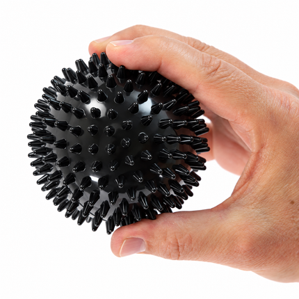 Firm black 9 cm spiky massage ball in hand